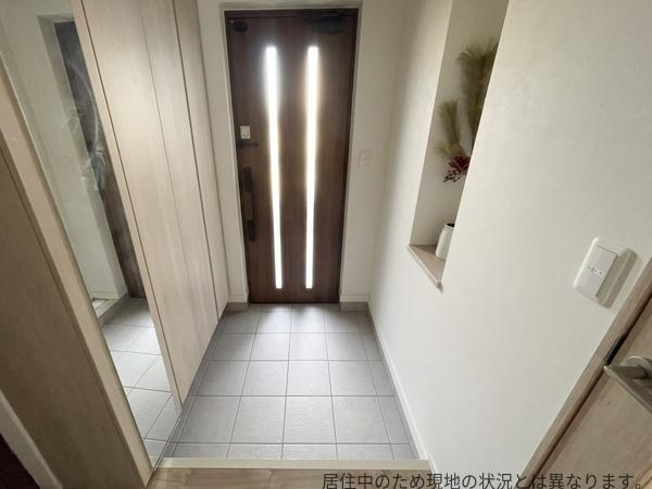 京が丘南4丁目　中古の玄関|明るい玄関が印象的です。床と壁が落ち着いた色合いでまとめられています。大型の収納スペースがあり便利です。ドアの縦型ガラス窓が光を取り入れています。