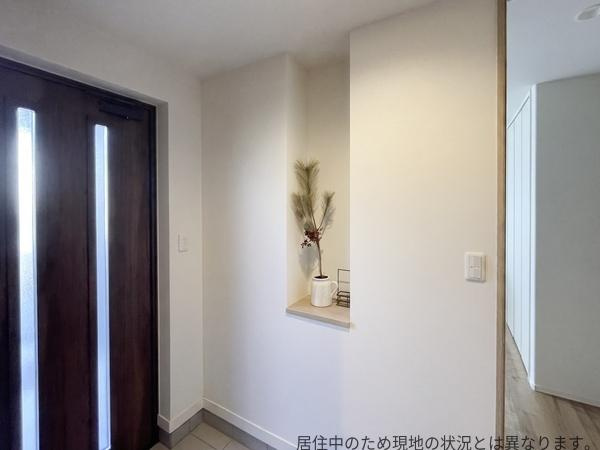 京が丘南4丁目　中古の玄関|玄関にはニッチが設けられており、鍵やお花など様々な物を置くことができます。ナチュラルなアクセントが印象的で、落ち着いた雰囲気の玄関です。木目調のドアが空間に温かみを加えています。