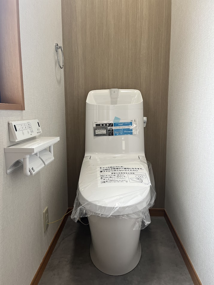 仙台市青葉区みやぎ台5丁目のトイレ|お洒落なナチュラル内装：背面に温かみのある木目調のアクセントクロスを採用。