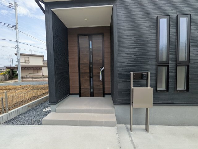 石岡市石岡　3期　新築戸建ての玄関|お洒落な玄関ドアと洗練された外壁デザイン。家の顔にふさわしい上質な佇まいで、ご家族やお客様を迎えます。