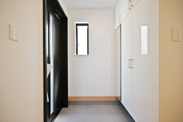 ハートフルタウン東園田町3丁目新築一戸建て全6区画│4LDK+駐車2台可 の玄関|1階玄関をホール側から撮影した内観写真です。 シンプルな玄関扉にシューズボックス、小窓を配置したオーソドックスな玄関です。