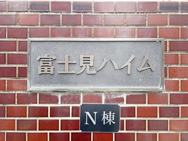 【現況写真】 | 富士見ハイム北（N）棟 | エントランスに掲げられた、マンション名を示す館銘板。さほど激しく主張はしませんが、しっかりと掲示されています。～即日のご見学可能～　お問合せはお気軽にどうぞ。
