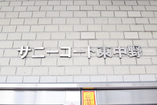 【現況写真】 | サニーコート東中野 | エントランスに掲げられた、マンション名を示す館銘板。さほど激しく主張はしませんが、しっかりと掲示されています。～即日のご見学可能～　お問合せはお気軽にどうぞ。