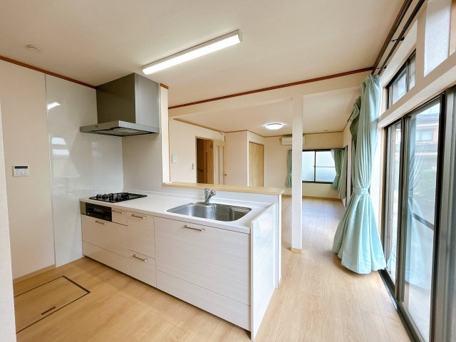 野木町南赤塚のキッチン|交換した対面式システムキッチン。3口コンロで複数の調理を同時に進めやすく、床下収納も備えています。