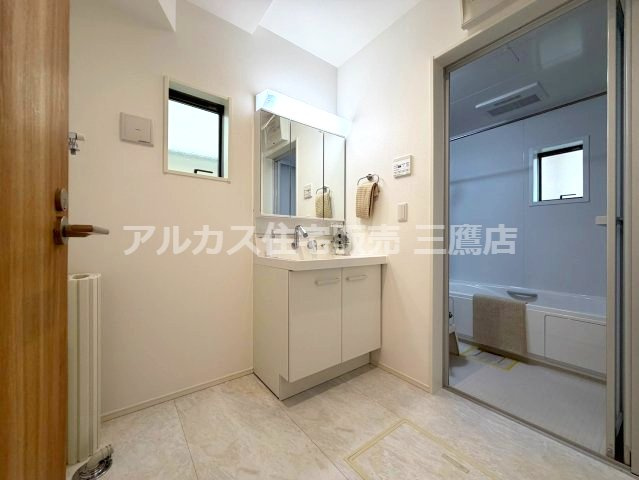 京王線 調布駅 バス6分 中古戸建 三鷹市大沢4丁目の独立洗面台|三面鏡付き洗面化粧台を備えた洗面室。小窓付きで、身支度や毎日の家事を快適にこなせる空間です。