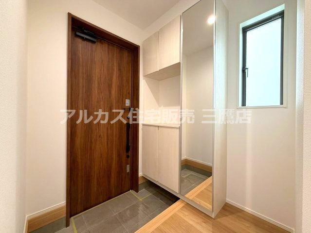 京王線 調布駅 バス6分 中古戸建 三鷹市大沢4丁目の玄関|玄関には姿見付きのシューズ収納を備え、お出かけ前の身だしなみ確認にも便利な空間です。
