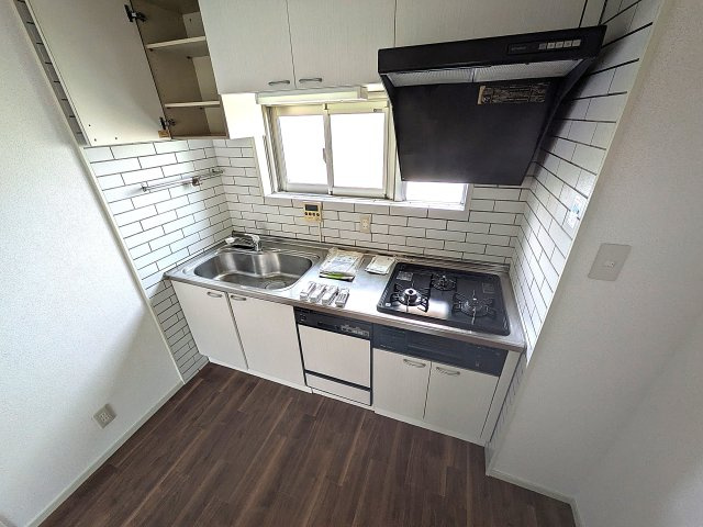 高倉台2-1団地9号棟のキッチン|3口ガスコンロ付きのシステムキッチン、窓も有ります