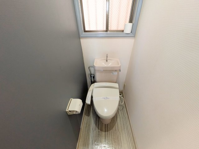 南持田町戸建てのトイレ|清潔感のある温水洗浄便座付きトイレです。小窓からやわらかな自然光が差し込み明るい印象です。
