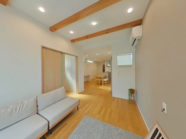 岡山市北区平田戸建の居間・リビング|化粧梁をあしらった高天井で解放感と奥行きを感じます。