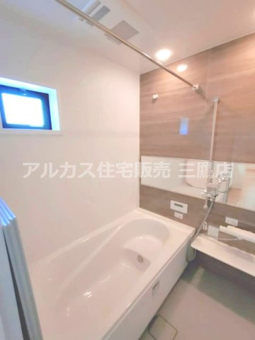 西武拝島線 東大和市駅 10分 新築戸建 小平市小川町1丁目の浴室|木目調の壁面が落ち着きを添え、小窓と物干しバーを備えた使い勝手の良い浴室です。
