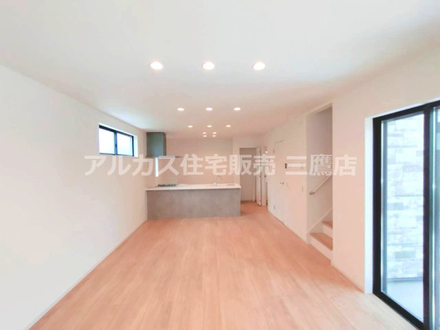 西武拝島線 東大和市駅 10分 新築戸建 小平市小川町1丁目の居間・リビング|白を基調とした内装に木目の床が調和し、奥の対面キッチンまで見渡せる一体感あるLDKです。
