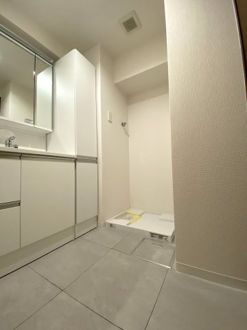 ローズアヴェニュー西巣鴨の脱衣所|脱衣所
洗面化粧台や洗濯機置き場がまとまった機能的なパウダールーム。入浴時の着替えや朝の身支度動線がスムーズで、毎日快適にお使いいただける清潔感あふれる使いやすいレイアウトです