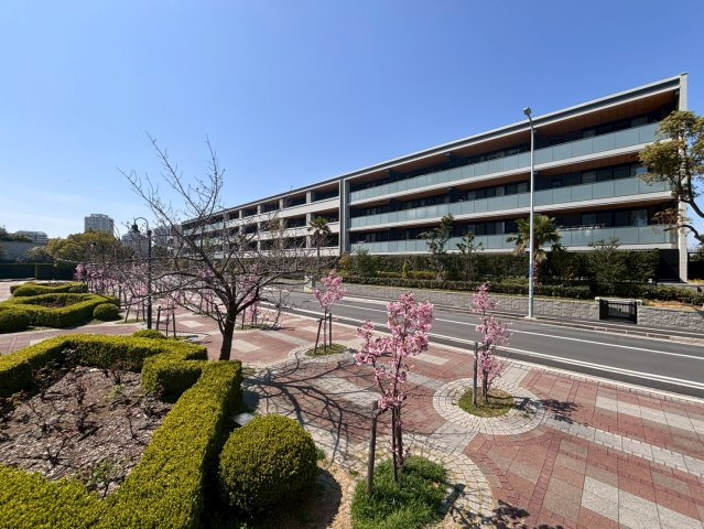 敷地南東側からの外観。バルコニー軒裏をイエローに、バルコニー側サッシ回りをダークトーンにしたメリハリの効いたカラーリングです。また、マンション周辺には日の出おひさま公園をはじめ、多くの緑が広がります。