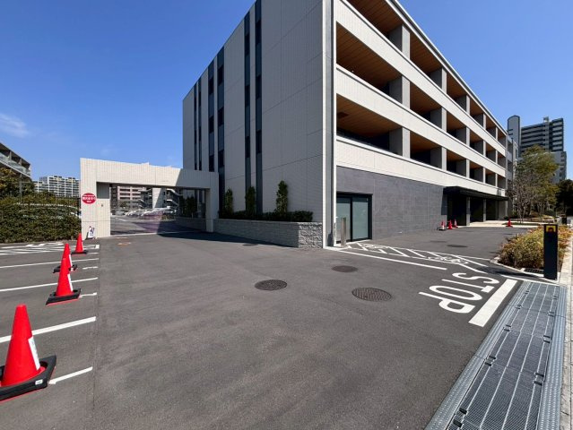 敷地南西側に面した駐車場出入口。シャッター外に来客用駐車場有り（8：00～20：00は100 円/1時間。20:00～翌8:00は1,000円/1回）。