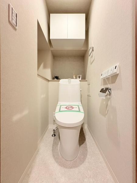 ベイサイトコート横浜のトイレ|上部収納が設置されているためトイレ用品の整理がしやすいです。壁リモコンタイプで操作も手軽に行えます。清潔感のある内装でシンプルなデザインが特徴です。床がフラットで掃除もしやすい仕様です。