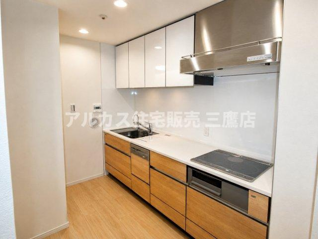 LAYERS HOUSE 杉並善福寺川公園のキッチン|食洗機やIHクッキングヒーターを備えた、木目調扉が美しいシステムキッチン。