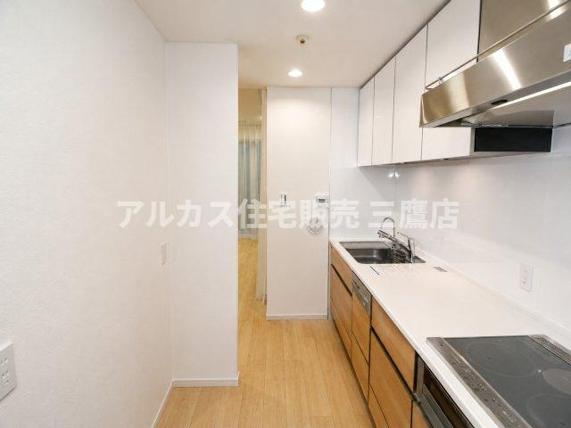 LAYERS HOUSE 杉並善福寺川公園のキッチン|食洗機やIHクッキングヒーターを備えた、木目調扉が美しいシステムキッチン。