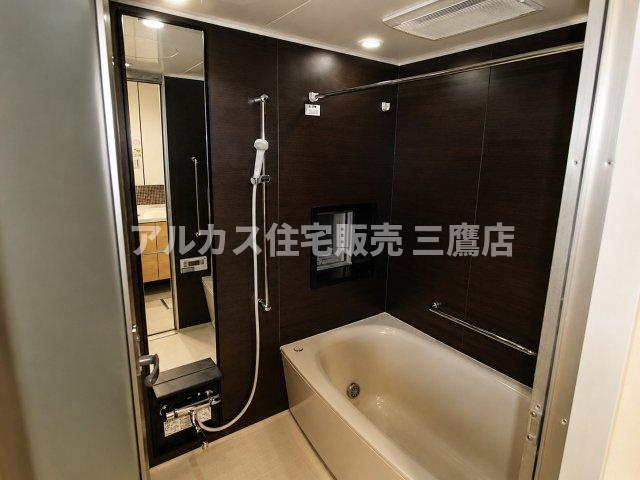 LAYERS HOUSE 杉並善福寺川公園の浴室|シックなダークトーンの壁パネルが高級感を演出する、清潔感あふれるバスルーム。
