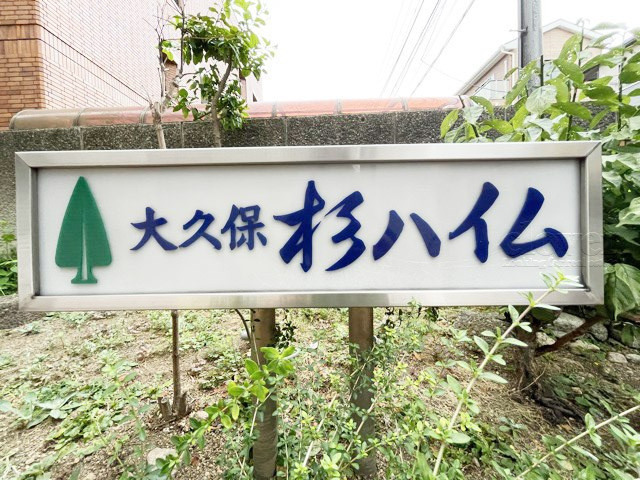 【現況写真】 | 大久保杉ハイム | エントランスに掲げられた、マンション名を示す館銘板。さほど激しく主張はしませんが、しっかりと掲示されています。～即日のご見学可能～　お問合せはお気軽にどうぞ。