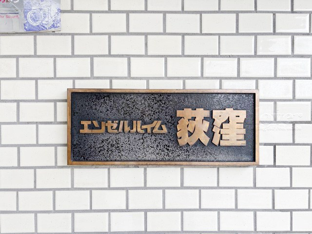 【現況写真】 | エンゼルハイム荻窪 | エントランスに掲げられた、マンション名を示す館銘板。さほど激しく主張はしませんが、しっかりと掲示されています。～即日のご見学可能～　お問合せはお気軽にどうぞ。