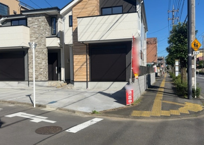 【前面道路含む現地写真】 | 元本郷町新築戸建 | 整備された歩道が続く南側15m・西側4mの公道。角地ならではの開放感があり、お車の駐車作業やすれ違いもスムーズです。小学校徒歩10分圏内、スーパー徒歩10分以内と子育て環境にも恵まれた好立地です。