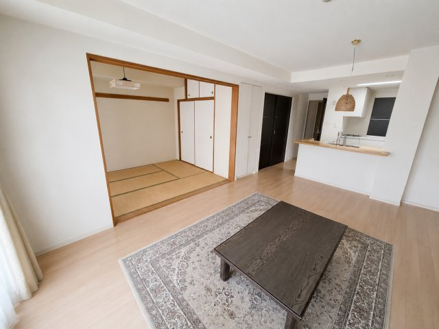 サンクレイドル竜南ウィンフォート　静岡市葵区竜南１丁目の居間・リビング|隣接する和室と一体利用で開放感あふれるLDK。対面キッチンを備え、ご家族との時間を快適に楽しめる空間