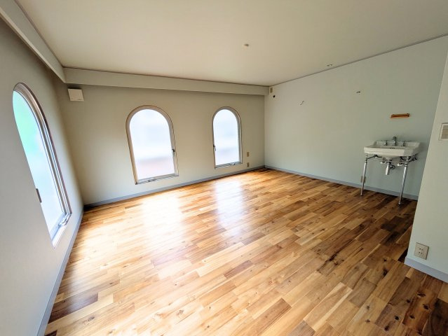 溝辺町戸建ての洋室|アーチ型の窓からやわらかな光が差し込む洋室。お部屋の中に洗面台があり身支度もスムーズです。