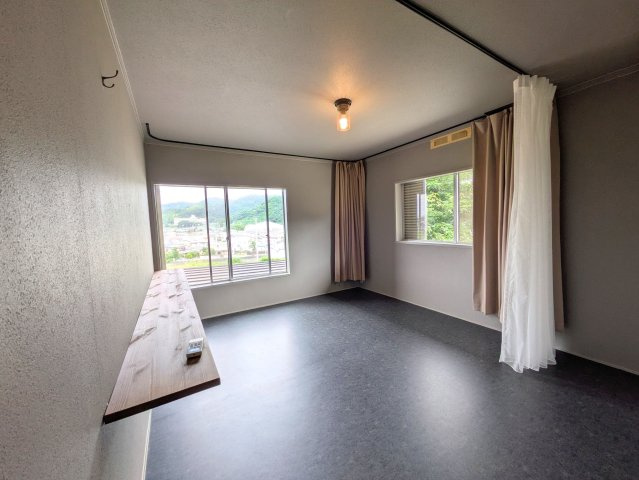 溝辺町戸建ての洋室|落ち着いたカラーで統一されたモダンなお部屋。壁付けカウンターはデスクワークや読書に重宝します。