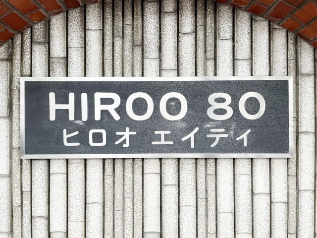 【現況写真】 | 広尾80 | エントランスに掲げられた、マンション名を示す館銘板。さほど激しく主張はしませんが、しっかりと掲示されています。～即日のご見学可能～　お問合せはお気軽にどうぞ。