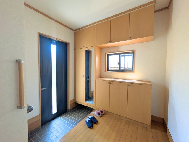 北条戸建ての玄関|姿見付きの大型玄関収納を備えた玄関ホール。小窓から光が入り、お出かけ前のチェックもスムーズです。