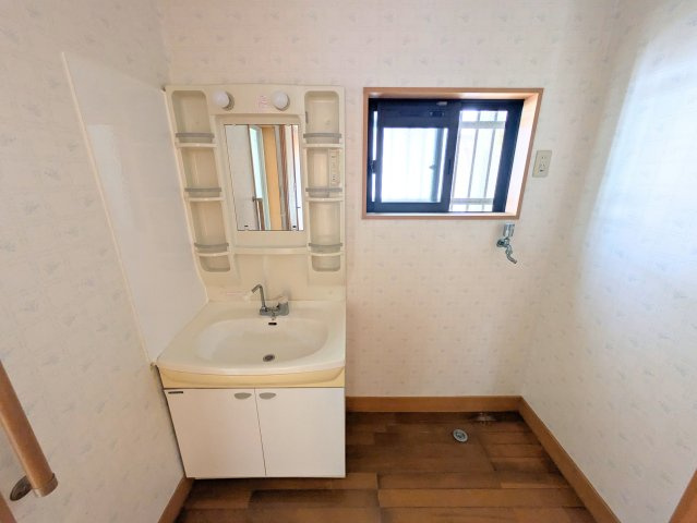 北条戸建ての独立洗面台|鏡横に棚を備えた洗面化粧台。小窓が付いているため通風が良く、朝の身支度も快適に行えます。