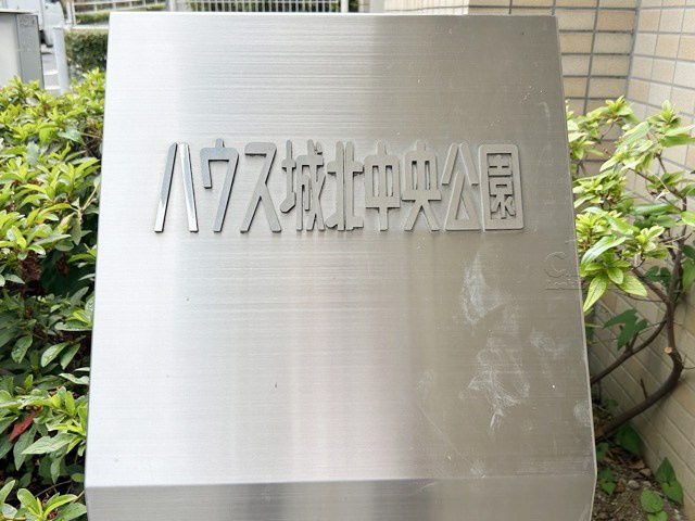【現況写真】 | ハウス城北中央公園 | エントランスに掲げられた、マンション名を示す館銘板。さほど激しく主張はしませんが、しっかりと掲示されています。～即日のご見学可能～　お問合せはお気軽にどうぞ。