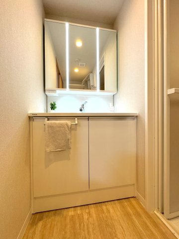 サニーコート川口元郷第２の独立洗面台|【洗面台】
機能的な洗面化粧台と洗濯機置場をすっきりと配置した脱衣スペース。リネン類や買い置きの備品をきれいに整理できる収納棚も備え、快適な朝の身支度をサポートします。