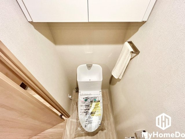 アンビックス志賀ストリートタワーのトイレ|トイレットペーパーのストックや掃除用具を生活感を隠して収納できる、便利な吊戸棚付きのトイレです。