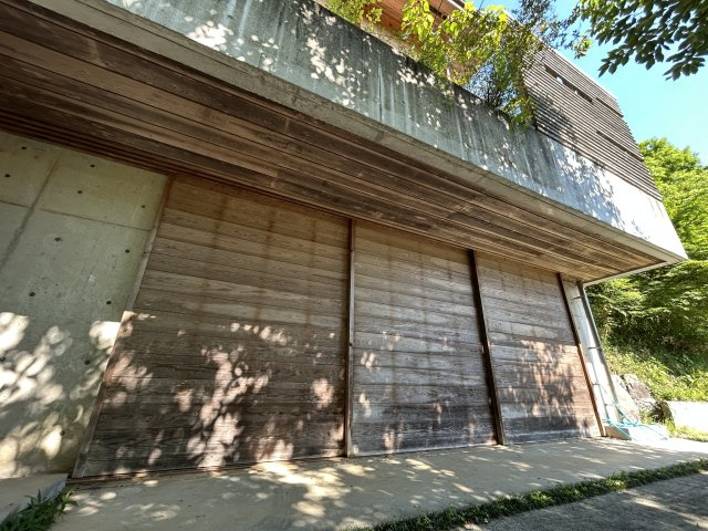 自然と呼応する、圧倒的に独創的な美しさ「住める芸術」　熊本県玉名市山田の外観|堅牢なRCと木の面構え。訪れる人を優しく、かつ誇り高く迎え入れる、住まいの風格があり
ます。