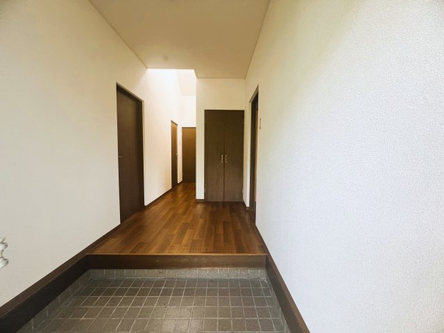 熊本県熊本市南区城南町東阿高　～令和8年7月リフォーム！内外装綺麗で快適な住環境～の玄関|木目調の廊下と収納扉が落ち着いた温かみある空間