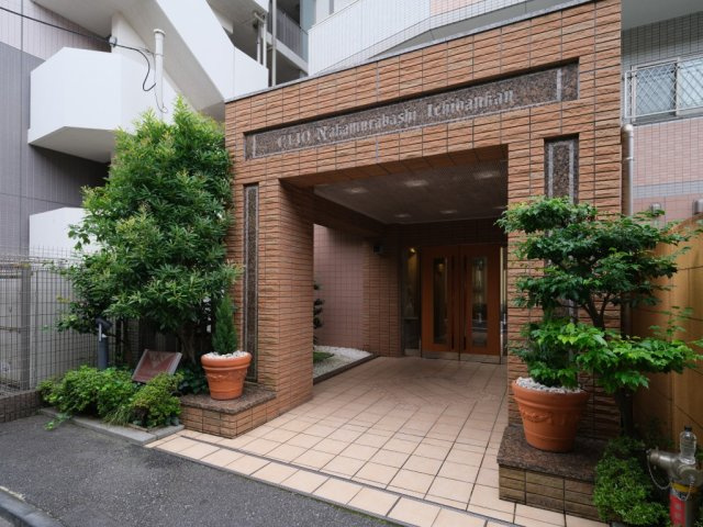 クリオ中村橋壱番館のエントランス|落ち着いたタイル貼りのエントランスが住まいの顔として住民やゲストを迎えます。植栽が丁寧に手入れされており、管理体制の良さが伺えます
