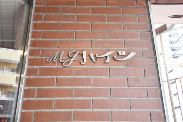 【現況写真】 | MJハイツ | エントランスに掲げられた、マンション名を示す館銘板。さほど激しく主張はしませんが、しっかりと掲示されています。～即日のご見学可能～　お問合せはお気軽にどうぞ。