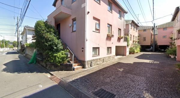 【前面道路含む現地写真】 | ポルフィド石が敷かれた位置指定道路を囲むように、花かごを取りつけた窓が並ぶ街並み