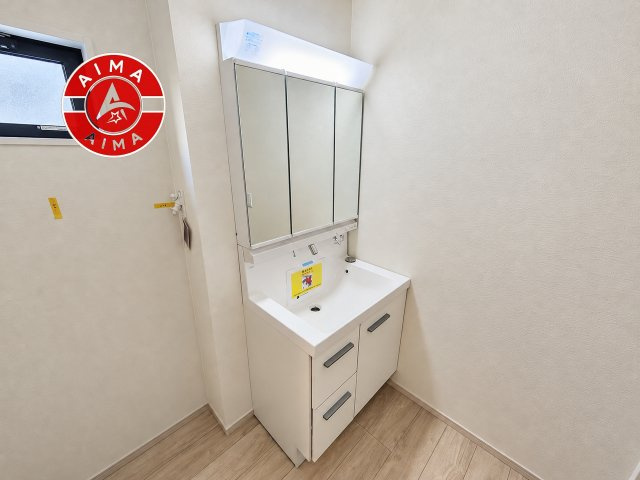 福岡市早良区有田2丁目第1-3棟（2号棟）の内観：施工例|毎日使うものだから清潔な空間を保ちたい水回り。洗面にはそんな願いを解消させてくれる収納アイデアが満載です。三面鏡の裏側にはキャビネットが現れ小物から背の高い物まで収納できます。