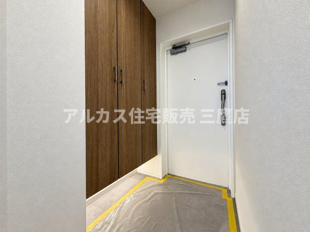 コンフレックス善福寺公園の玄関|白いクロスと木目調のシューズボックスが調和する清潔感のある玄関。フロートタイプの収納下部からは優しい明かりが漏れ、足元を明るく穏やかに照らします。