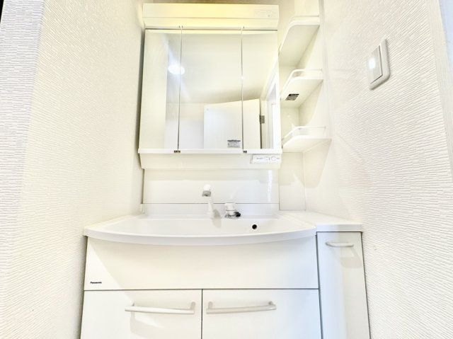 RICイーストコート4番街5番館の独立洗面台|三面鏡の裏や足元の収納に加え、便利なサイドオープン棚と引き出しを完備した洗面台。化粧品や歯ブラシ、タオルなどを適材適所にすっきり収納できます。散らかりがちな洗面空間を常に美しく保てる仕様です。