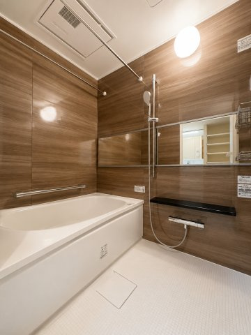 虹ヶ丘マンション本館の浴室|木目調のパネルが落ち着いた雰囲気を演出する浴室。浴室暖房乾燥機や手すりを備え、快適性と使いやすさに配慮されています。