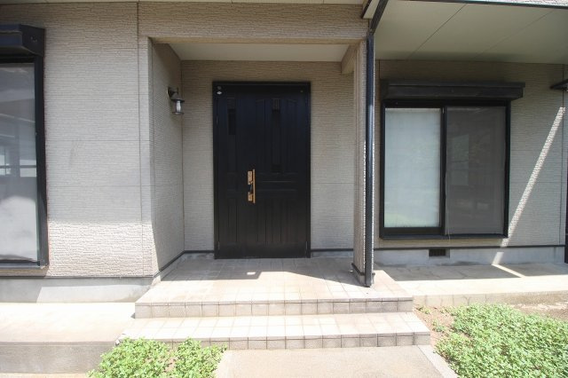小山市東城南5丁目の玄関|雨の日も出入りしやすい、屋根付きの玄関ポーチ。ゆとりのある階段とアプローチで、毎日の出入りもスムーズです。