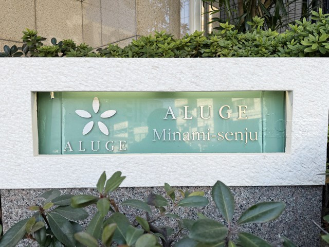 【現況写真】 | アリュージュ南千住 | エントランスに掲げられた、マンション名を示す館銘板。さほど激しく主張はしませんが、しっかりと掲示されています。～即日のご見学可能～　お問合せはお気軽にどうぞ。