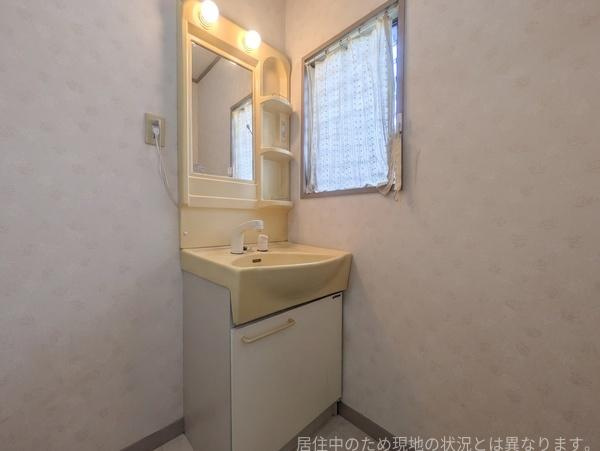 高城台4丁目　中古の独立洗面台|大きな鏡とライトが備わった洗面台です。収納スペースもあり小物の整理に役立ちます。明るい窓が近くにあり自然光も取り入れられます。シンプルなデザインで使いやすい仕様です。
