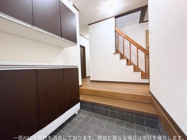 政所　中古の玄関|玄関は広々とした空間でシューズボックスが設置されています。床はタイル仕様でお手入れがしやすい印象です。明るい照明が全体を照らし落ち着いた色合いの内装です。階段へのアクセスもスムーズなレイアウトです。