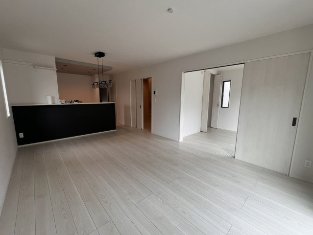 狭山市柏原 中古戸建｜駐車3台可・対面式キッチン、白を基調とした美しい室内、開放感あるLDKの邸宅の居間・リビング