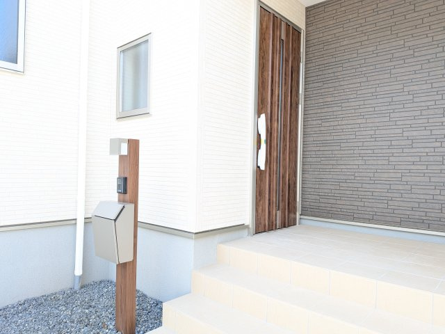 リーブルガーデン知多市日長台第3の玄関|木目調が温かみのある玄関ドアとポスト