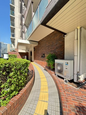 クローバーハイツ三宮|【アプローチ】エントランスへ続くアプローチです。レンガ調の壁面と、黄色い誘導ブロックが設置されたスロープ仕様になっています。